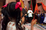 Students clap during the school event held at the US Embassy in Bangladesh for the people of Joypura. He observes the children with Fazle Hasan Abed, Bangladesh Rural Advancement Committee.