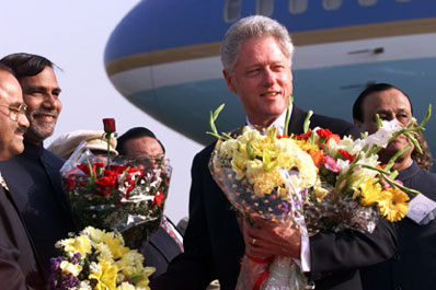President Clinton is presented with numerous floral  bouquets upon his arrival at Mumbai Airport.