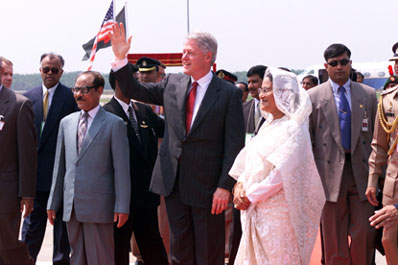 President Clinton, flanked by President Justice Shahabuddin Ahmed and Prime Minister Sheikh Hasina, waves to the crowds upon his arrival in Bangladesh.  Zia International Airport, Bangladesh.